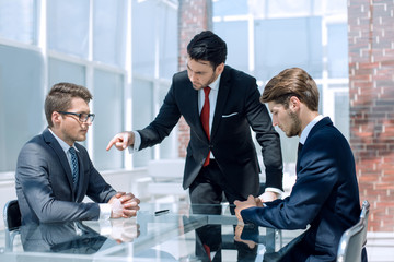 annoyed businessman scolds his employees