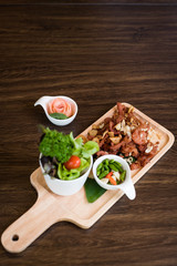 Fried Pork with Garlic. Deep Fried Crispy Pork Belly Cooked with Garlic and spicy dipping sauce on wooden table background