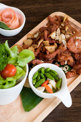 Fried Pork with Garlic. Deep Fried Crispy Pork Belly Cooked with Garlic and spicy dipping sauce on wooden table background