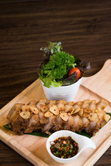 Fried Pork with Garlic. Deep Fried Crispy Pork Belly Cooked with Garlic and spicy dipping sauce on wooden table background