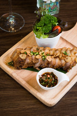 Fried Pork with Garlic. Deep Fried Crispy Pork Belly Cooked with Garlic and spicy dipping sauce on wooden table background