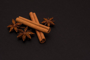 cinnamon sticks and cardamom on a black background top view with copy space for text