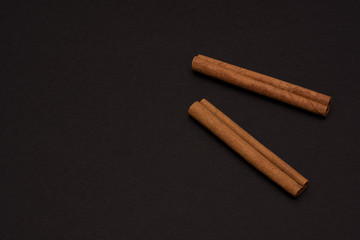 cinnamon sticks on black background top view with copy space for text