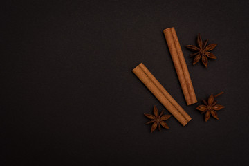 cinnamon sticks and cardamom on a black background top view with copy space for text