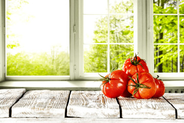 Summer photo of red tomatoes and window landscape. 