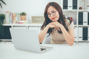 Happy young businesswoman with glasses working on computer laptop in home office