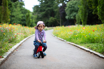 baby girl play bike at Summer forest park