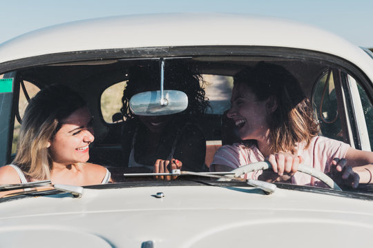 Laughing diverse women traveling by car