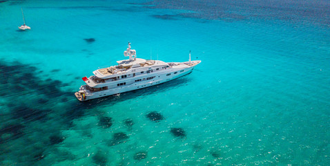 Big luxury yacht anchoring in shallow water,