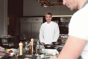 Chef preparing meal during cooking classes in restaurant kitchen