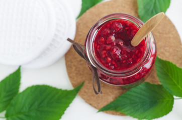 Homemade raspberry jam in a small glass jar. Selective focus,  copy space.
