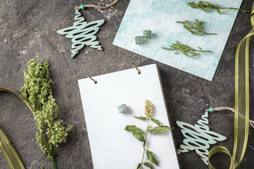 Composition with items for scrapbooking and green plants on grey background