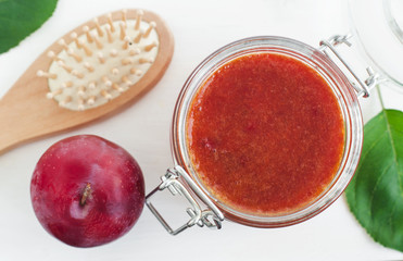 Homemade plum smoothie face and body mask/scrub in a glass jar. DIY cosmetics and spa. Copy space.  