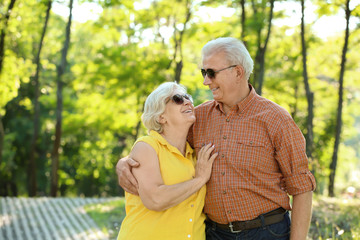 Happy mature couple walking in city park