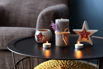 Table with burning candles in living room