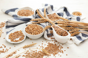 Composition with wheat grains and spikelets on wooden background