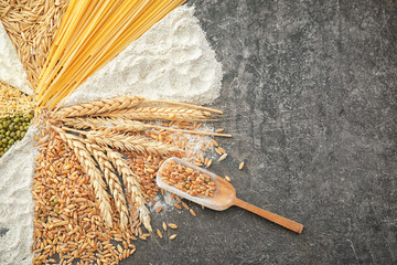 Composition with wheat flour, cereals and pasta on grey background