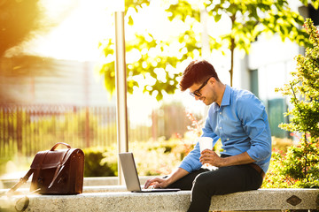 young office man with coffee cup outside