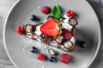 Piece of delicious chocolate cake with berries on plate