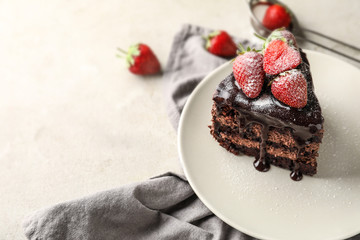 Piece of delicious chocolate cake with strawberry on plate