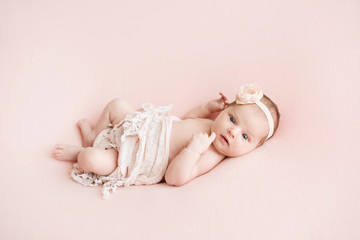Newborn girl on a pink background. Photoshoot for the newborn. 7 days from birth. A portrait of a...