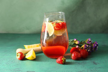 Tasty natural lemonade with strawberries in glass jug on table