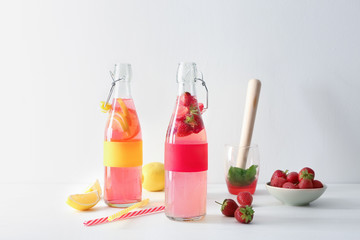 Natural lemonade with strawberry in glass bottles on table
