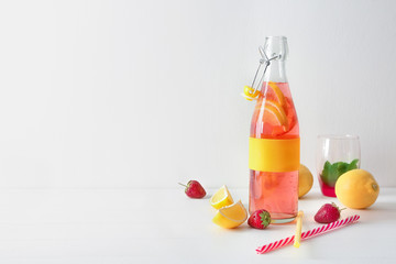 Natural lemonade with strawberry in glass bottle on table
