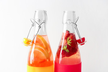 Natural lemonade with strawberry in glass bottles on white background