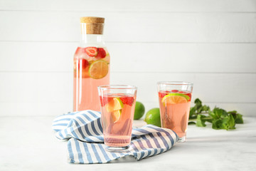 Natural lemonade with strawberry in bottle and glasses on table
