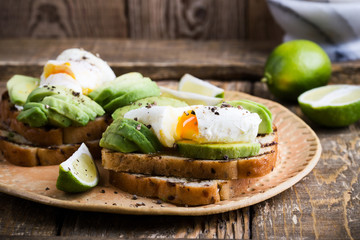 Poached egg and sliced avocado on whole wheat bread toast