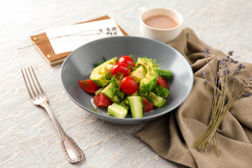 Plate with tasty vegetable salad on table