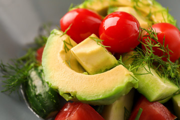 Tasty salad with avocado and tomatoes in bowl, closeup