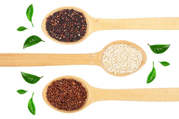 Black red white quinoa seeds in wooden spoon decorated with green leaves isolated on white background. Top view