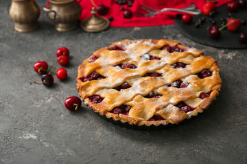 Delicious cherry pie with fresh berries on table