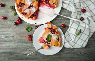 Delicious homemade cherry pie with fresh berries on wooden table