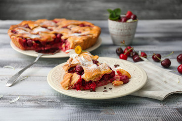 Plate with piece of delicious cherry pie on wooden table