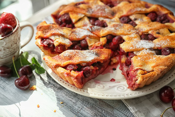 Plate with delicious homemade cherry pie on wooden table