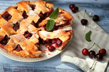 Plate with delicious homemade cherry pie on wooden table