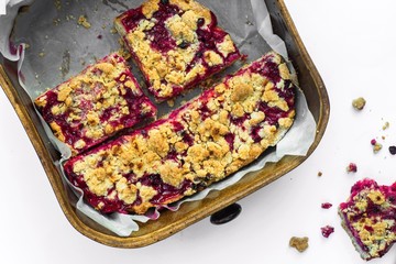 Red currant cake in pan on white.