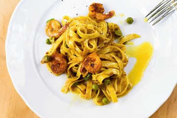 Tagliatelle with shrimps and pea on plate.