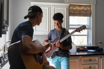 Male Teenage Boy Friends Playing Guitar