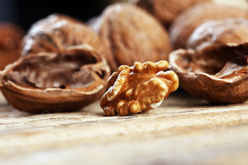 Walnut kernels and whole walnuts on rustic old table.
