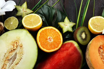 Assortment of tropical fruits with leaves of palm trees and exotic plants