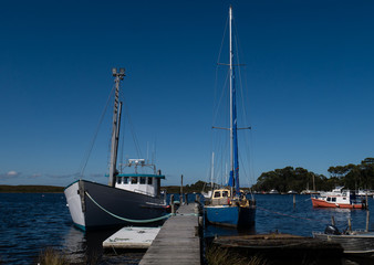 Boats moored in Morse Bay, Strahan on the west coast of Tasmania, Australia.