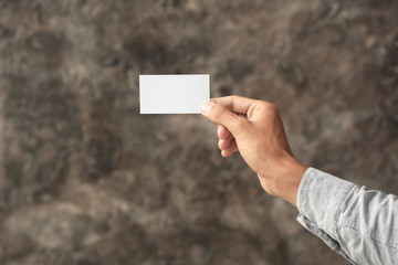 Man with business card on blurred background