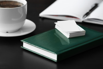Fototapeta premium Blank business cards with notebook on table
