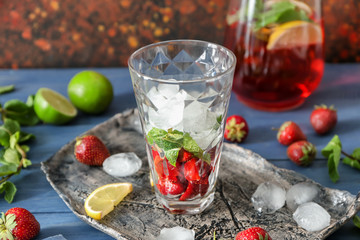 Glass of tasty strawberry lemonade on table