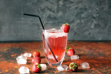Glass of tasty strawberry lemonade on table