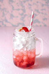 Mason jar with tasty strawberry lemonade on table